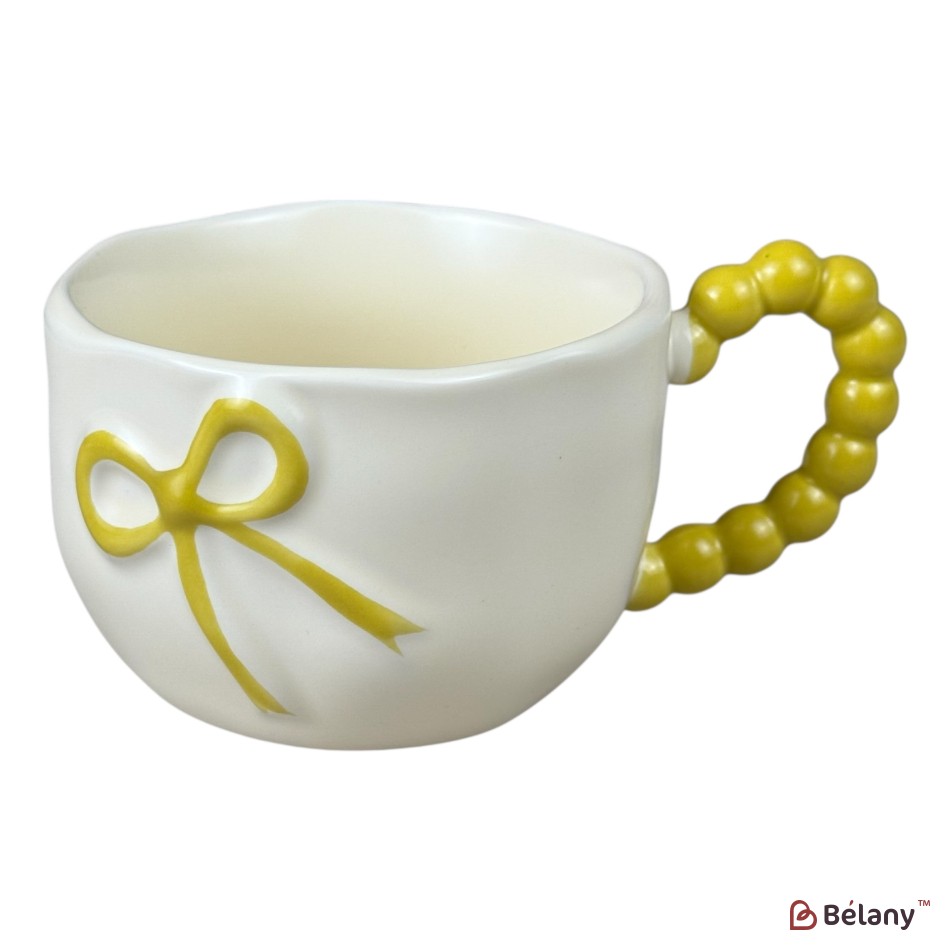 Cană din ceramică „Bow Handle” galbenă cu fundiță în relief și mâner tip mărgele, 360 ml