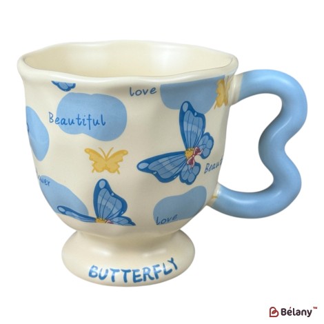 Cană din ceramică „Butterfly” crem cu fluturi albaștri și mâner albastru ondulat, 400 ml