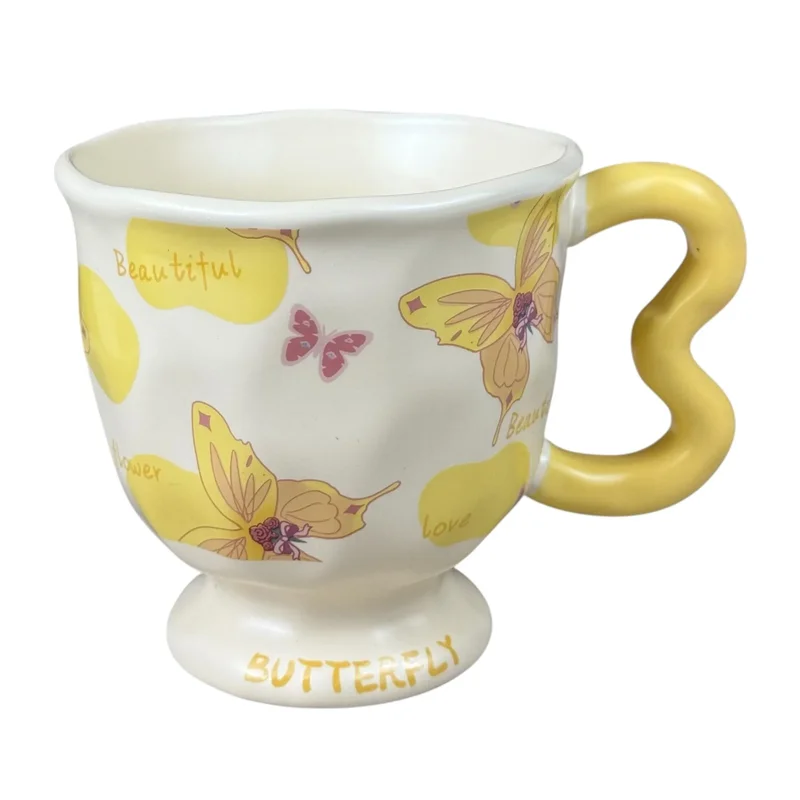 Cană din ceramică „Butterfly” crem cu fluturi galbeni și mâner galben ondulat, 400 ml